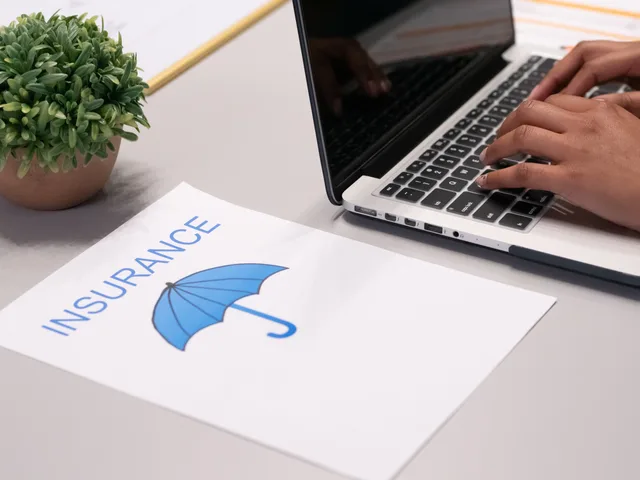 Close-up of hands typing on laptop with an insurance document visible on the desk. Angebote vergleichen: Kriterien für Leistung, Preis und Risiko